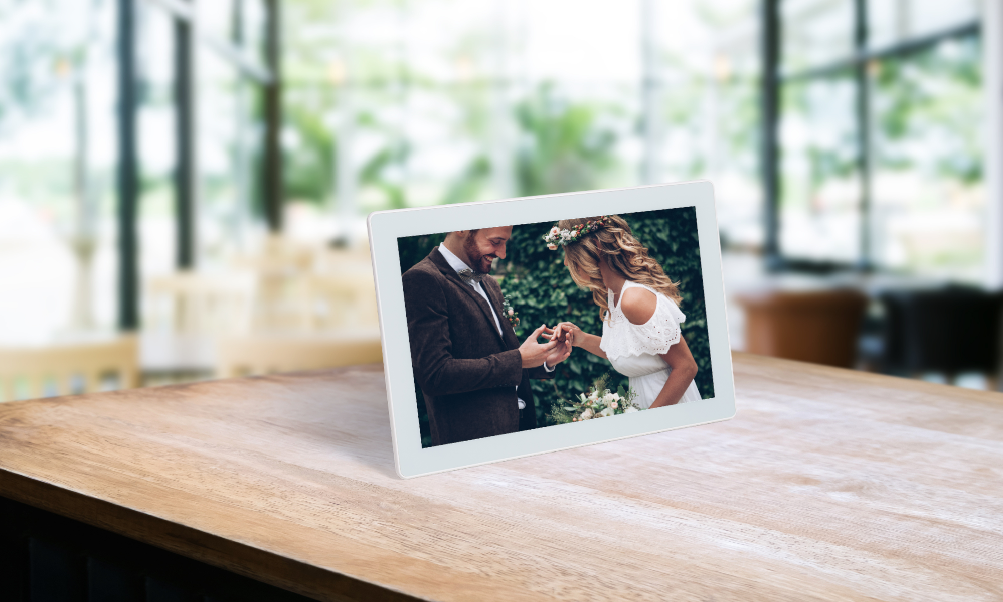 On the white digital Photospring frame, there is a groom proposing to the bride with a tree behind them.