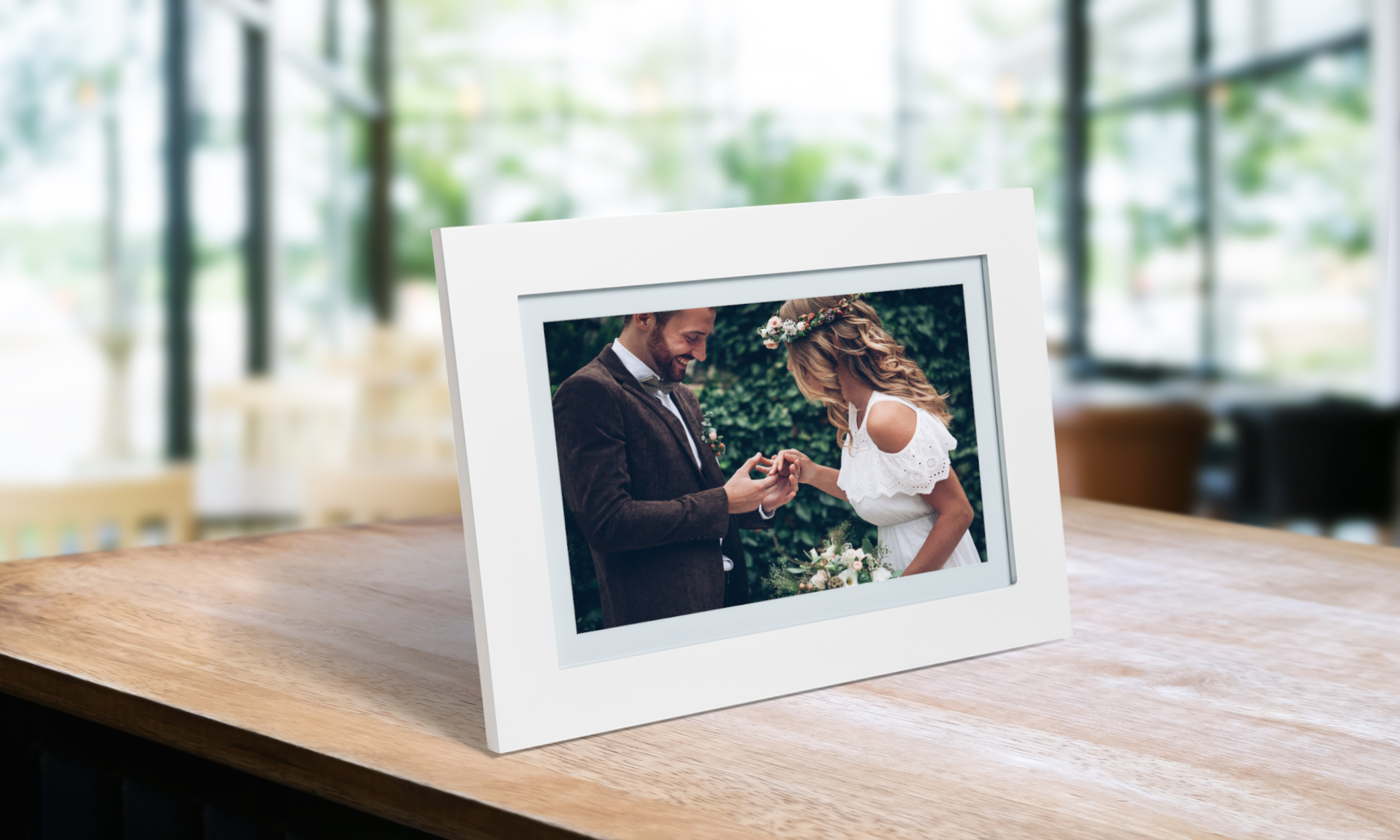 On the white digital Photospring frame, there is a groom proposing to the bride with a tree behind them.