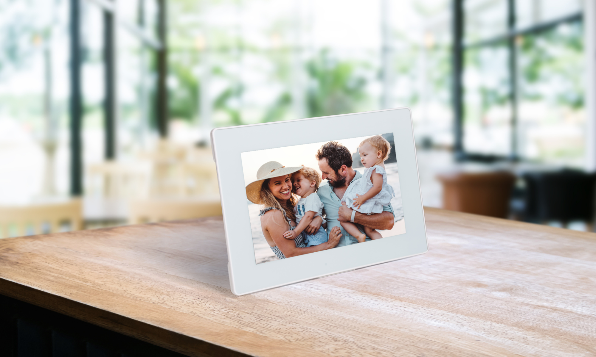 A white digital frame with a family of 4 looking at each other and smiling